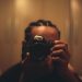 Homem negro ajustando a lente de uma câmera fotográfica com o automático desligado